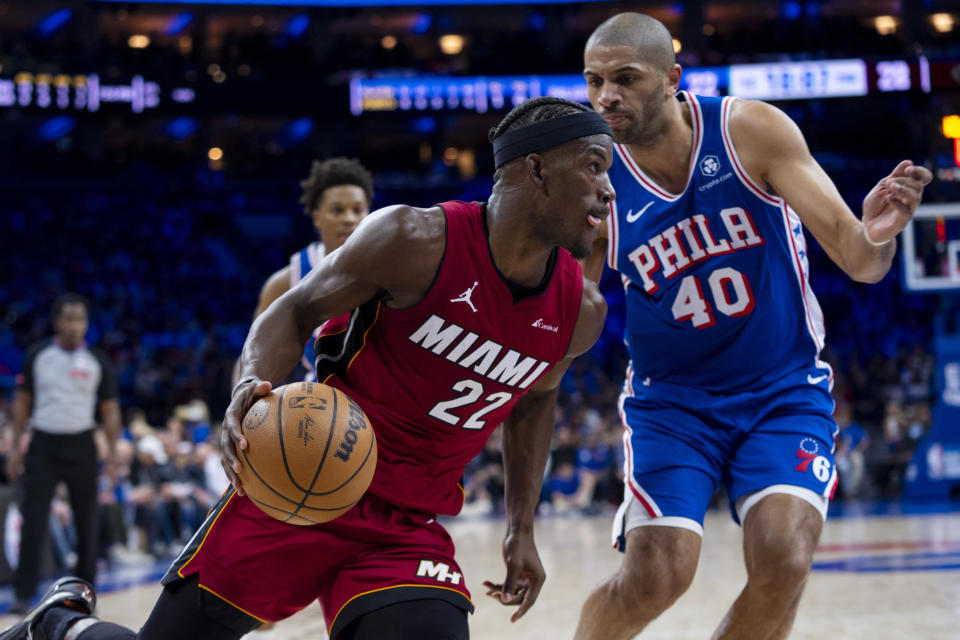 Miami Heat's Jimmy Butler, left, drives to the basket against Philadelphia 76ers' Nicolas Batum during the first half of an NBA basketball play-in tournament game Wednesday, April 17, 2024, in Philadelphia. (AP Photo/Chris Szagola)