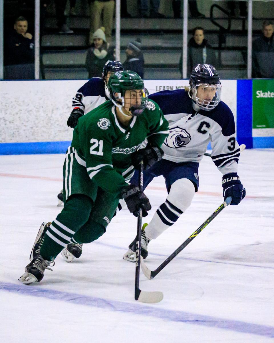 Marshfield's Teddy Devoe is chased down the ice by Plymouth North’s Sean Hallissey..