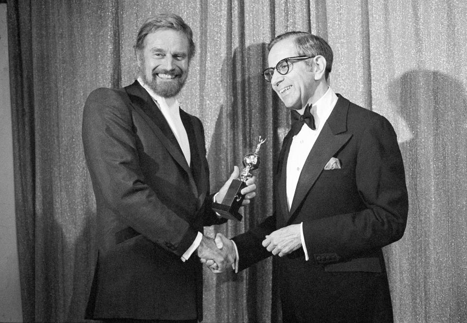 FILE - Walter Mirisch, right, and Charlton Heston celebrate at the 34th annual Golden Globe awards, presented by the Hollywood Foreign Press Association at the Beverly Hilton in Los Angeles, on Jan. 29, 1977. Mirisch, the astute and Oscar winning film producer who oversaw such classics as “Some Like It Hot,” “West Side Story” and “In the Heat of the Night,” has died of natural causes, the Academy of Motion Picture Arts and Sciences said Saturday, Feb. 25, 2023. He was 101. (AP Photo, File)