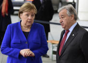 German Chancellor Angela Merkel, left, speaks with United Nations Secretary General Antonio Guterres during arrivals for a conference on Libya at the chancellery in Berlin, Germany, Sunday, Jan. 19, 2020. German Chancellor Angela Merkel hosts the one-day conference of world powers on Sunday seeking to curb foreign military interference, solidify a cease-fire and help relaunch a political process to stop the chaos in the North African nation. (AP Photo/Jens Meyer)