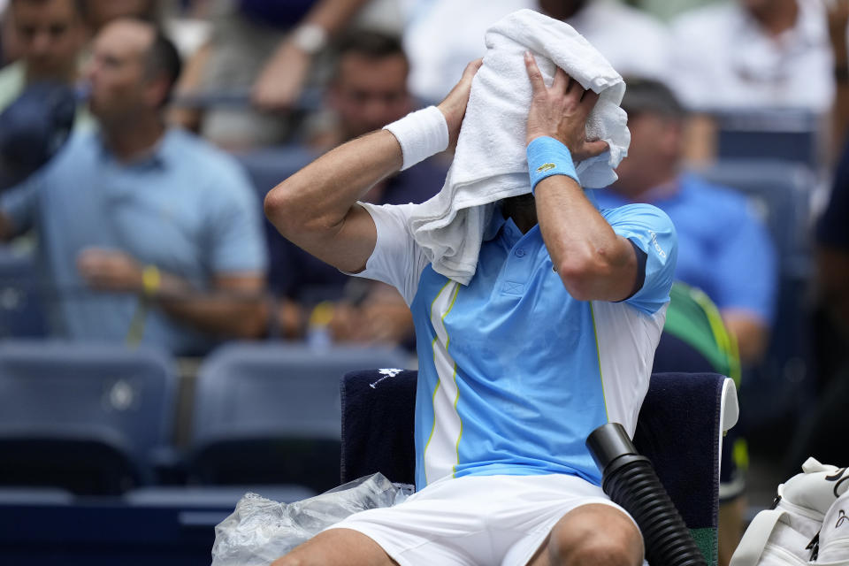 Novak Djokovic, of Serbia, wipes sweat from his face during a break between games against Taylor Fritz, of the United States, during the quarterfinals of the U.S. Open tennis championships, Tuesday, Sept. 5, 2023, in New York. (AP Photo/Seth Wenig)