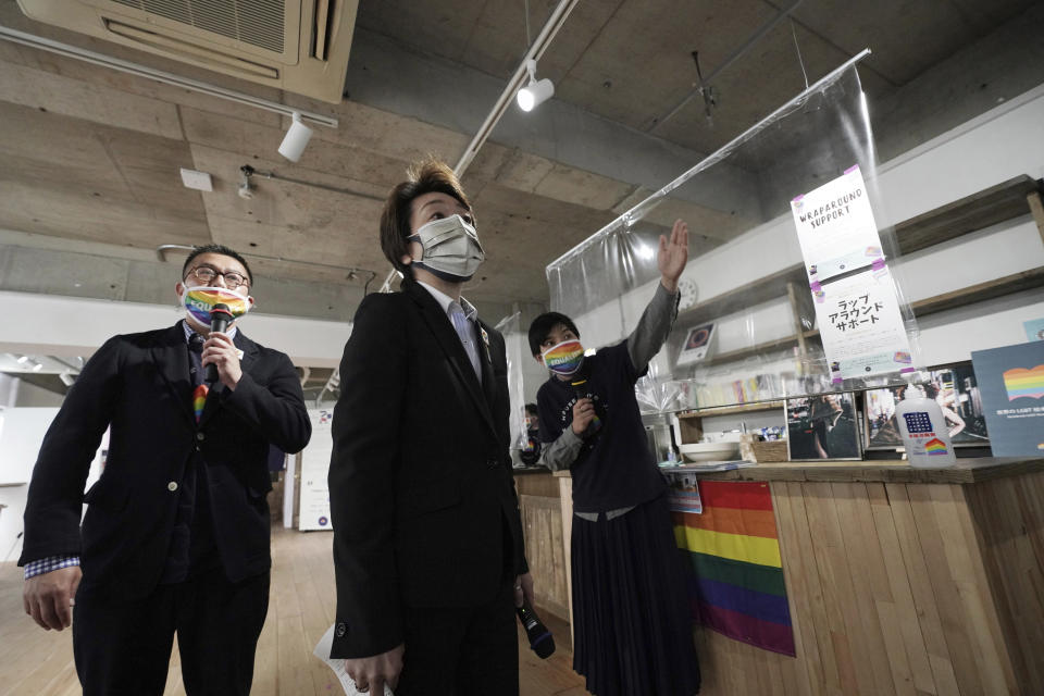 Tokyo 2020 Organizing Committee President Seiko Hashimoto, center, is guided Gon Matsunaka, left, head of Pride House Tokyo Legacy, and another staff during her visit to the house in Tokyo Tuesday, April 27, 2021. Japan marked LGBTQ week with pledge to push for equality law before the Olympics. (AP Photo/Eugene Hoshiko, Pool)