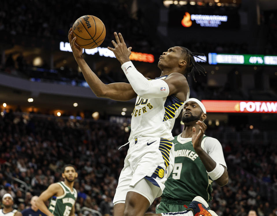 Indiana Pacers' Benedict Mathurin shoots against the Milwaukee Bucks Bobby Portis Jr. during the first half of an NBA basketball game, Monday, Jan. 1, 2024, in Milwaukee. (AP Photo/Jeffrey Phelps)