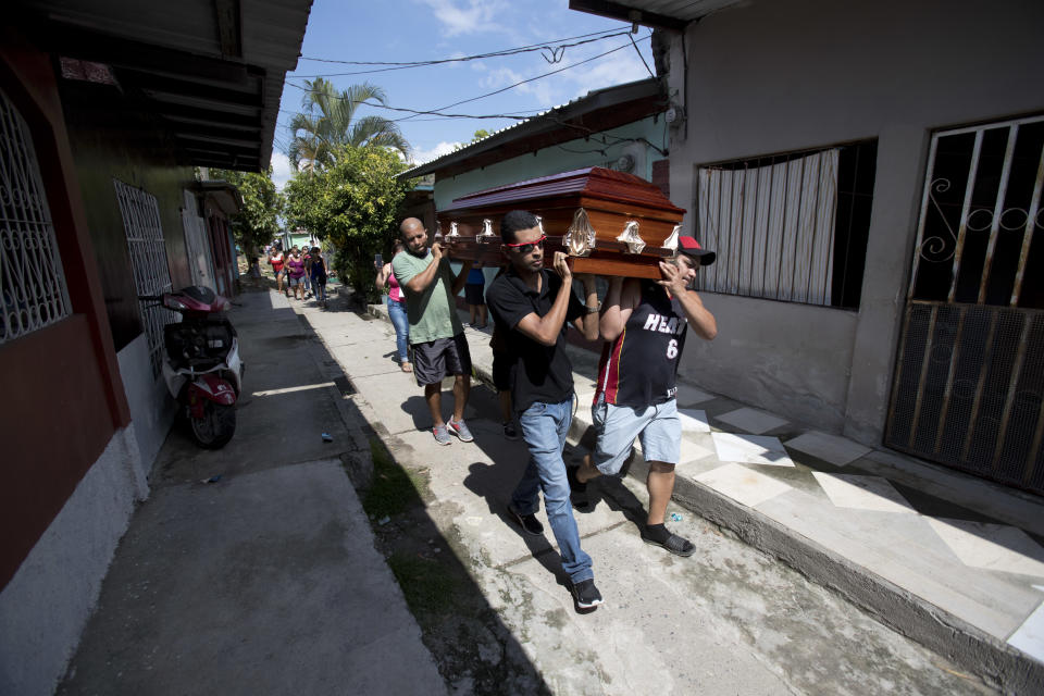 In this Oct. 31, 2018 photo, pallbearers carry the coffin that contain the remains of Wilmer Gerardo Nunez, in the Ciudad Planeta neighborhood of San Pedro Sula, Honduras. Nunez left for the U.S. the first time in the 1990's, at age 16. "He did not say anything to me. One day he simply left," recalls his mother Haydee Posadas. (AP Photo/Moises Castillo)