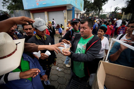 Volunteers hand out food to Honduran migrants, part of a caravan trying to reach the U.S., before continuing a new leg of their travel in Esquipulas, Guatemala October 16, 2018. REUTERS/Jorge Cabrera