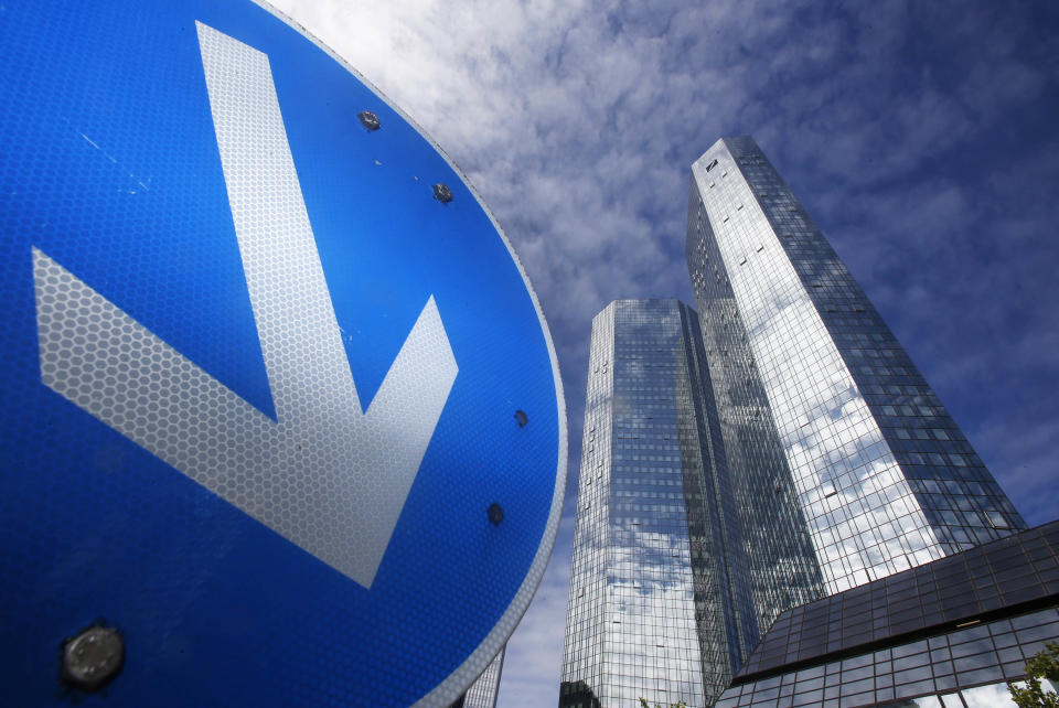 FILE - In this July 30, 2013 file photo a traffic sign stands near the headquarters of Deutsche Bank in Frankfurt, Germany. Shares of Deutsche Bank AG have fallen sharply after Germany's biggest lender announced a large fourth-quarter net loss, its results weighed down by one-time expenses and losses on investments it is disposing of to strengthen its finances. The bank on Sunday night, Jan. 19, 2014 posted a fourth-quarter net loss of 965 million euros (US dollar 1.3 billion), an announcement that came 10 days before it was scheduled to release its results. (AP Photo/Michael Probst, File)