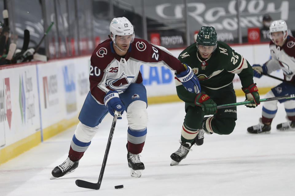 Colorado Avalanche's Brandon Saad (20) handles the puck in front of Minnesota Wild's Kevin Fiala (22) during the second period of an NHL hockey game Wednesday, April 7, 2021, in St. Paul, Minn. (AP Photo/Stacy Bengs)