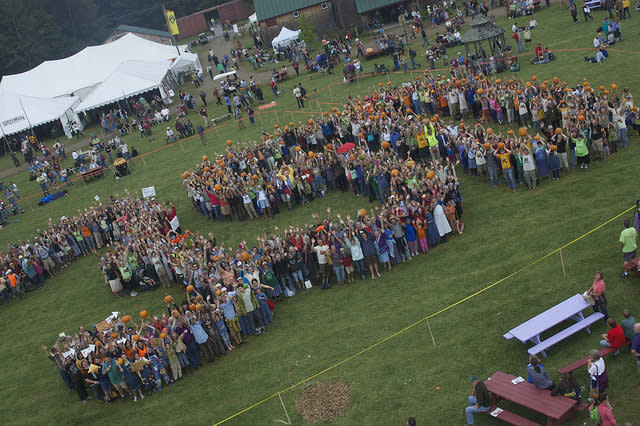 Led by Unity College students, over 500 Common Ground Fairgoers raise local organic pumpkins in a massive 350 to celebrate local agriculture solutions to climate change