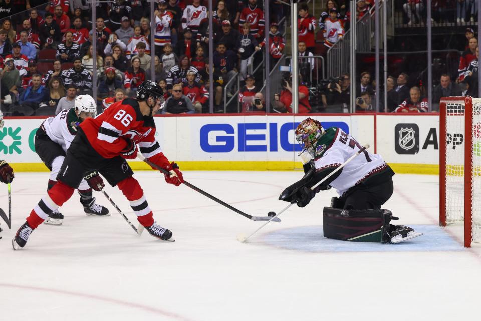 Coyotes goaltender Karel Vejmelka makes a save on New Jersey Devils center Jack Hughes (86) during overtime at Prudential Center on Friday night. The Coyotes won 4-3 in a shootout.