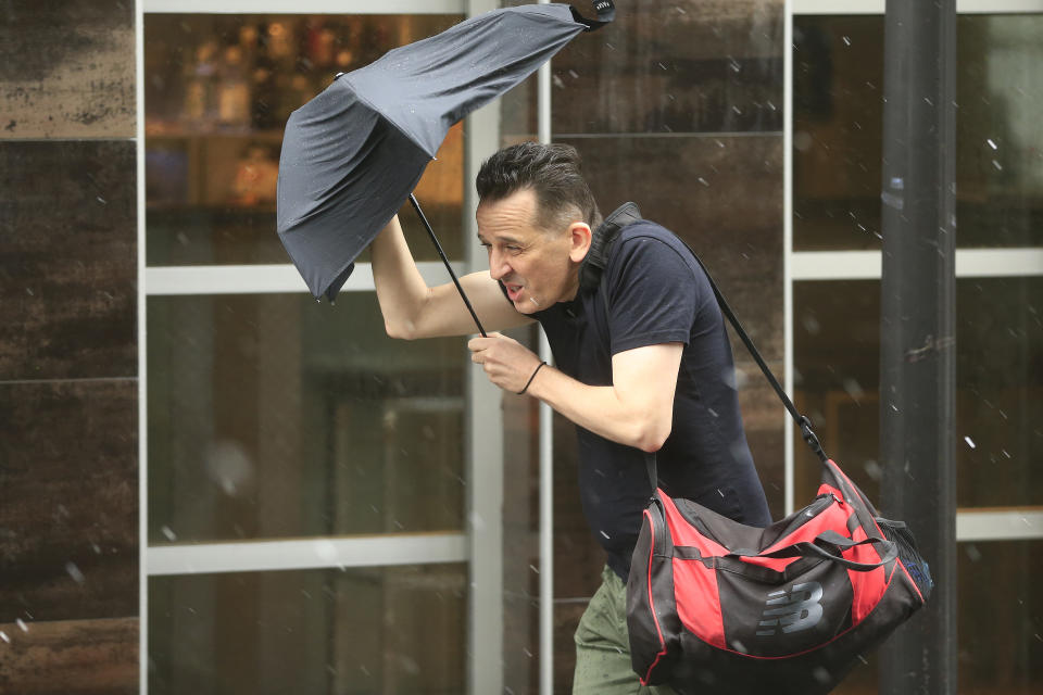 A man struggles with the wind and rain in Sydney.