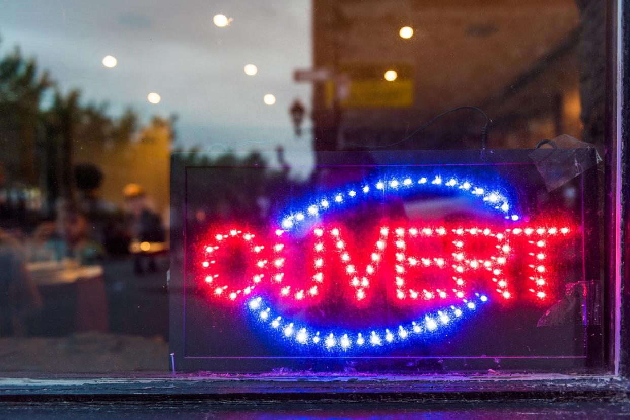 French ouvert open sign for store shop or restaurant glowing in the evening