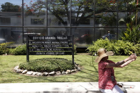 A tourist takes a selfie next to a sign that shows the Mossack Fonseca law firm's name outside their office building in Panama City April 13, 2016. REUTERS/Carlos Jasso