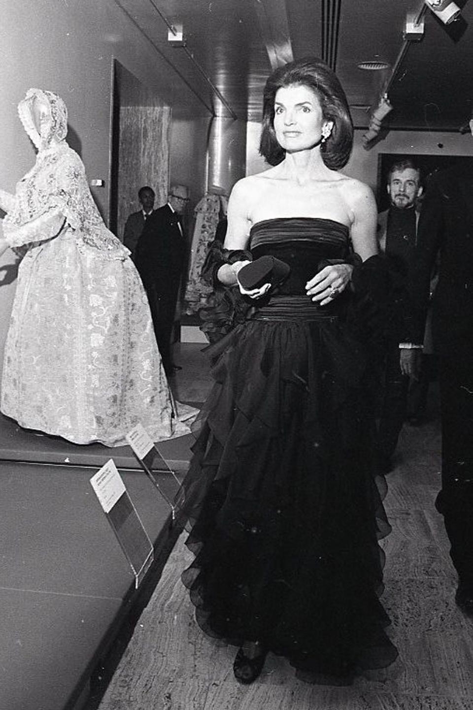 A graceful Jacqueline Kennedy walks through the galleries at the 1979 Met gala.