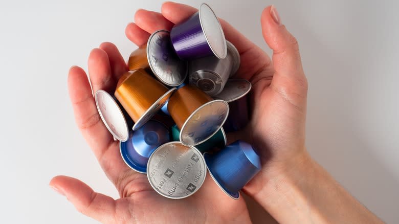 hands holding Nespresso pods