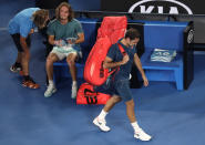 Switzerland's Roger Federer, right, leaves Rod Laver Arena after losing his fourth round match to Greece's Stefanos Tsitsipas at the Australian Open tennis championships in Melbourne, Australia, Sunday, Jan. 20, 2019. (AP Photo/Kin Cheung)