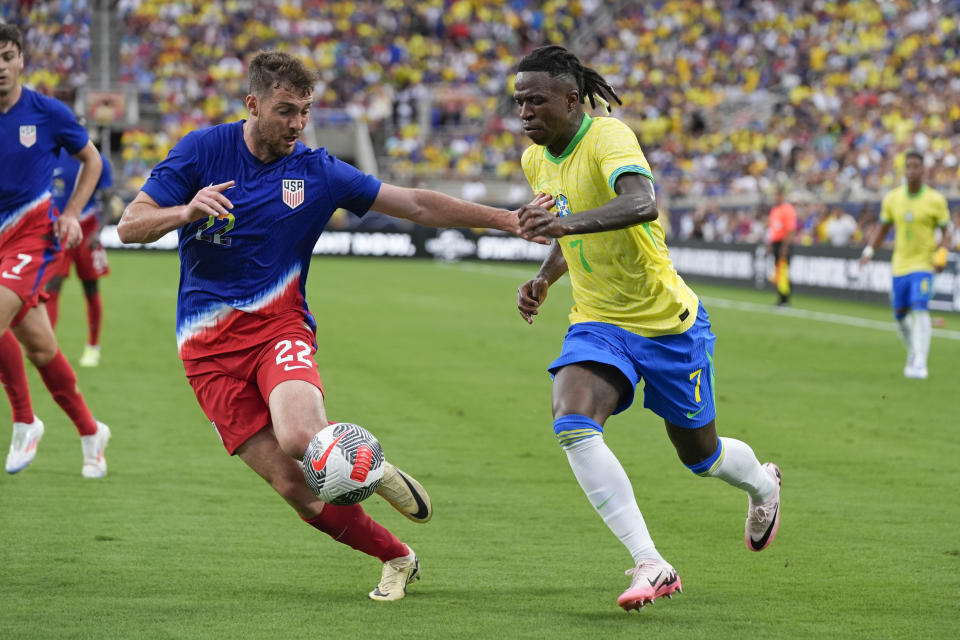 U.S. defender Joe Scally, left, tries to slow down Brazil forward Vinicius Junior (7) as he moves to the goal during the first half of an international friendly soccer match Wednesday, June 12, 2024, in Orlando, Fla. (AP Photo/John Raoux)