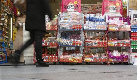 A pedestrian walk past a discount shop in Tokyo November 29, 2013. REUTERS/Yuya Shino