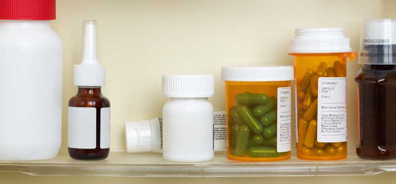 bottles of prescription medicine sitting on shelves in cabinet