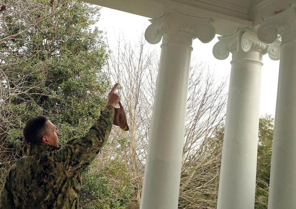 Naval Base Kitsap Commanding Officer Capt. Rich Massie points out the new columns that were installed on the historical home's front porch on Officers Row at Naval Base-Kitsap Bremerton on Dec. 18.