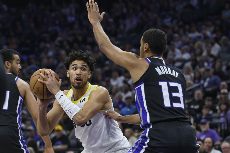 Utah Jazz guard Johnny Juzang, left, is guarded by Sacramento Kings forward Keegan Murray (13) during the first half of an NBA basketball game in Sacramento, Calif., Sunday, March 31, 2024. (AP Photo/Randall Benton)