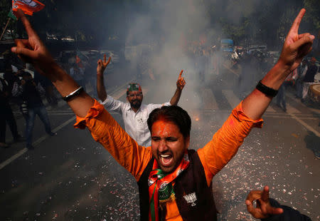 Supporters of Bharatiya Janata Party (BJP) celebrate after learning of the initial poll results outside the party headquarters in New Delhi, March 11, 2017. REUTERS/Adnan Abidi