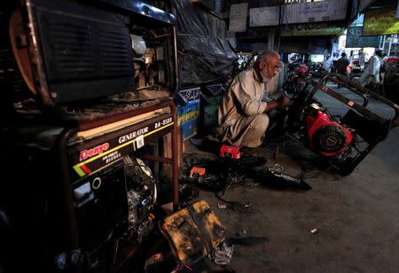 A generator mechanic works outside his shop in Rawalpindi, Pakistan, October 8, 2016. REUTERS/Faisal Mahmood