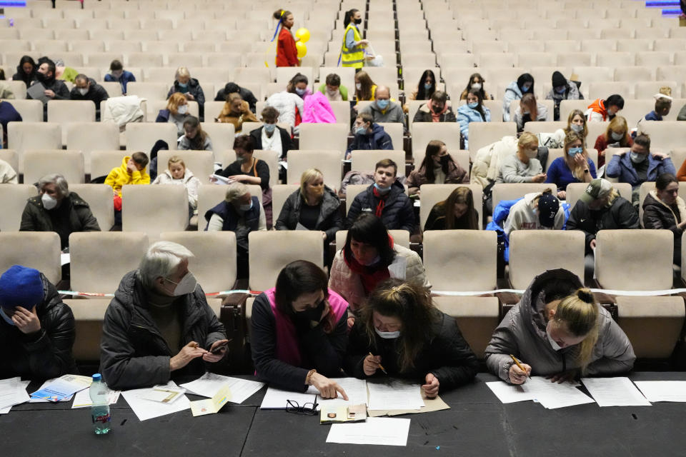 FILE - Refugees that fled the war in Ukraine fill in the paperwork to get registered, at the congress center in Prague, Czech Republic, March 15, 2022. Nearly six months after the Russian invasion of Ukraine, many refugees are still struggling to find jobs in their European Union host countries, despite the EU's streamlined process for Ukrainians to live and work in any of its 27 member nations. (AP Photo/Petr David Josek, File)