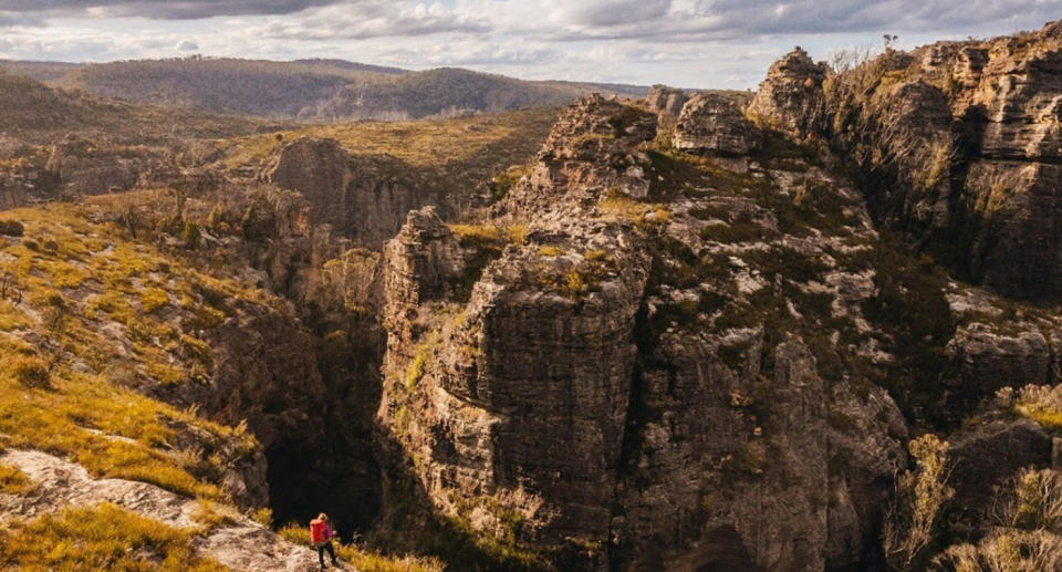 The untouched landscape of the Blue Mountains with a hiker alone on a track.