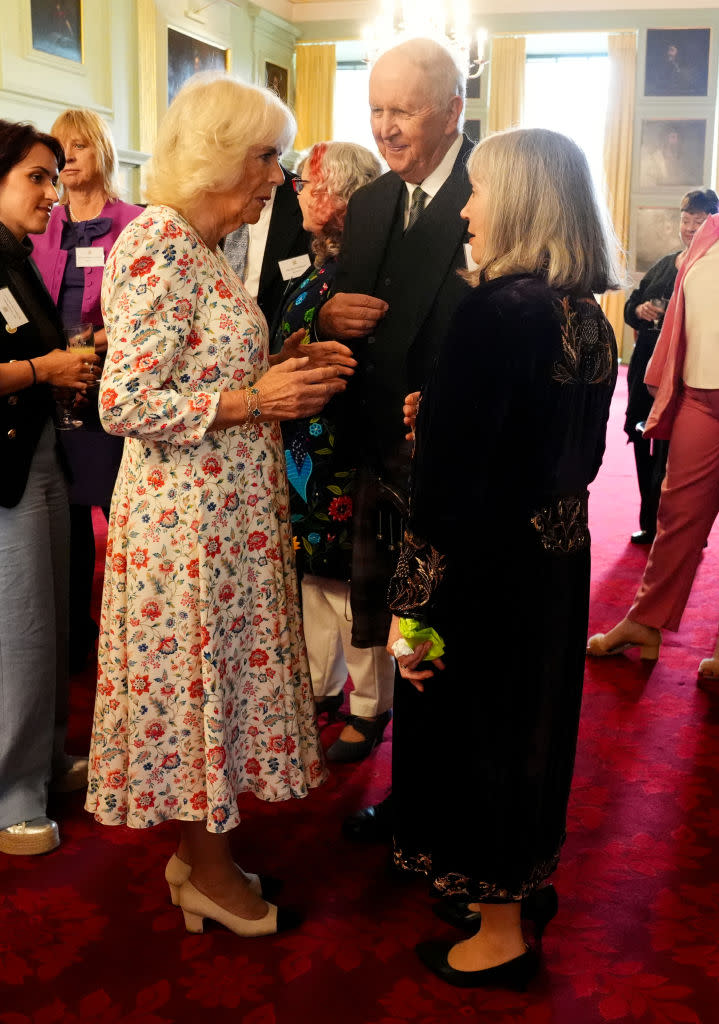 Britain's Queen Camilla wears vintage Chanel pumps, cap-toe shoes, color-blocked heels, Karl Lagerfeld shoes, and speaks to Elizabeth McCall Smith (R) and her husband Scottish Author Alexander McCall Smith (2R) during a celebration for those who work to promote Scottish Literacy, including book shop owners, authors, and representatives from the Edinburgh International Book Festival and the Scottish Book Trust, at the Palace of Holyroodhouse in Edinburgh, on July 2, 2024. 
