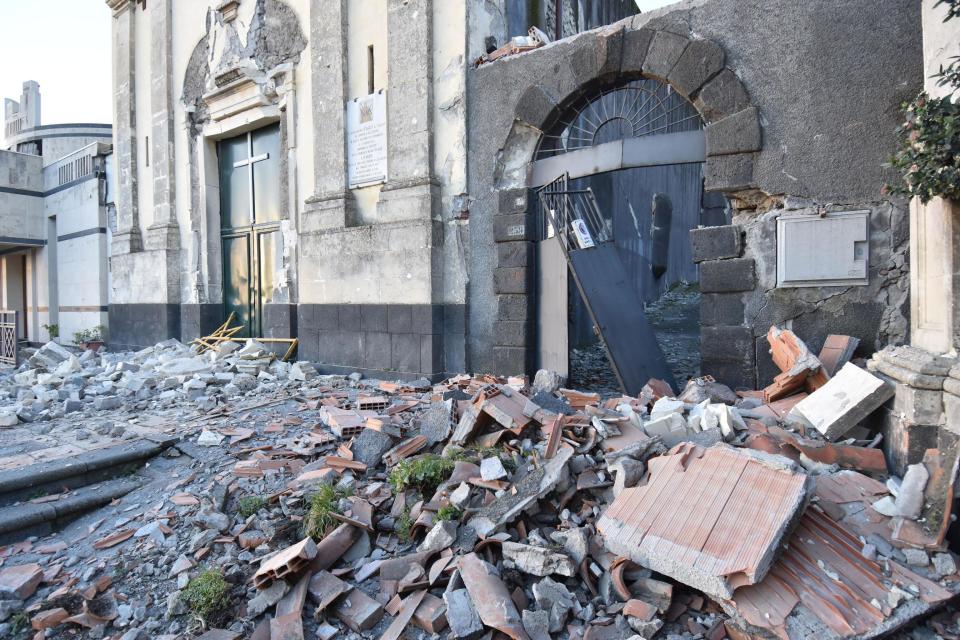 Debris stand in front of the heavily damaged church of Maria Santissima in Fleri, Sicily Italy, Wednesday, Dec. 26, 2018. A quake triggered by Italy's Mount Etna volcano has jolted eastern Sicily, slightly injuring 10 people and prompting frightened Italian villagers to flee their homes. (Orietta Scardino/ANSA Via AP)