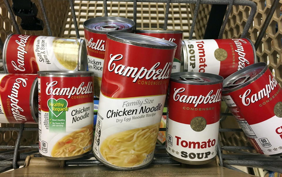 FILE - This May 23, 2017, file photo shows an assortment of Campbell's Soup in a grocery cart at a store in Phoenix.  Campbell Soup plans to focus on its core snacks and soup business in North America and sell its international business, paying off debt.  The Camden, N.J., Thursday, August 30, 2018, company said it is working urgently to complete all moves by next July.  (AP Photo/Ross D. Franklin, file)