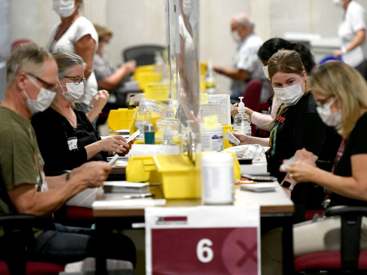 Workers count ballots on election night at Elections Canada's distribution centre in Ottawa. More than two months after Canadians went to the polls, some elections workers say they still haven't received their paycheques. (Justin Tang/Canadian Press - image credit)