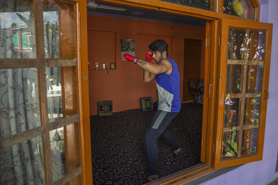Kashmiri boxer Eyed Akeel Khan practices inside his house in Srinagar, Indian controlled Kashmir, April 23, 2020. Like many other athletes, the coronavirus pandemic has restricted Khan to his home. But lockdown for the 7 million residents of Kashmir is nothing new and the ongoing restrictions due to the pandemic is not the first time he has had to practice his sport at home. (AP Photo/Dar Yasin)