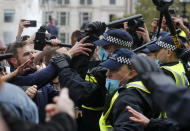 Riot police face protesters who took part in a 'We Do Not Consent' rally at Trafalgar Square, organised by Stop New Normal, to protest against coronavirus restrictions, in London, Saturday, Sept. 26, 2020. (AP Photo/Frank Augstein)