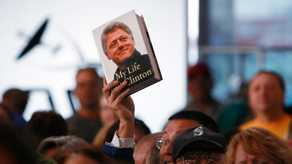 A book by former President Bill Clinton is held up as he speaks at a campaign event for Sen.