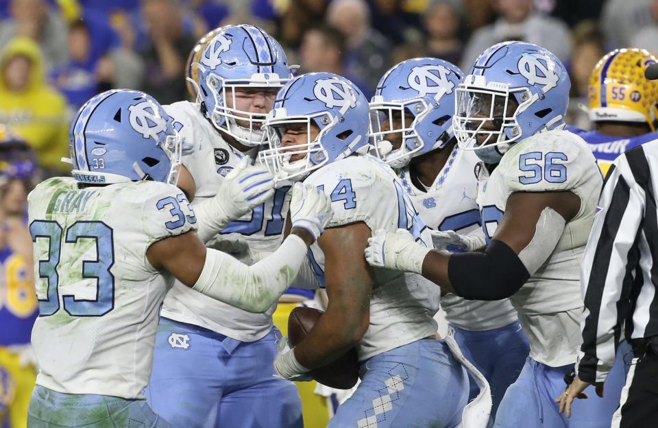 Inside linebacker Jeremiah Gemmel celebrates with North Carolina defensive teammates Cedric Gray, left, and Tomari Fox, right, after coming up with an interception against Pittsburgh in a November game at Heinz Field.