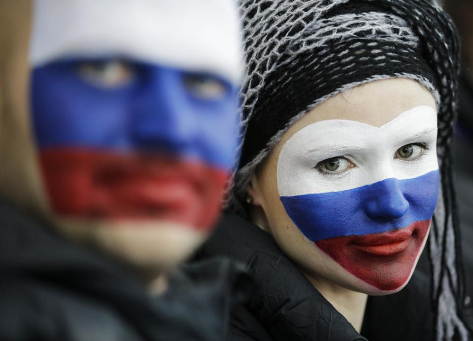 Russian skating fans, faces painted with the colors of their national flag, wait for the start of the women's 1,500-meter speedskating race at the Adler Arena Skating Center during the 2014 Winter Olympics, Sunday, Feb. 16, 2014, in Sochi, Russia. (AP Photo/David J. Phillip )