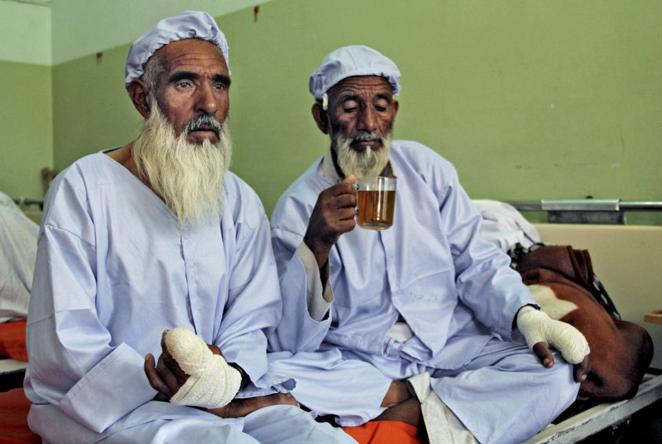 FILE- Afghan men, who their fingers have been cut off by Taliban fighters as a punishment for voting, rest in a hospital in Herat, west of Kabul, Afghanistan, Sunday, June 15, 2014. A U.N. report on Monday, May 8, 2023 condemned the Taliban for their harsh rule since seizing power in Afghanistan — including public execution, lashings, and amputations — and for ignoring international calls to respect human rights and freedoms. (AP Photo/Hoshang Hashimi, File)