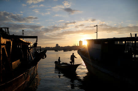 The sun rises as fishermen are seen at the seaport of Gaza City, after Israel expanded fishing zone for Palestinians April 2, 2019. REUTERS/Suhaib Salem