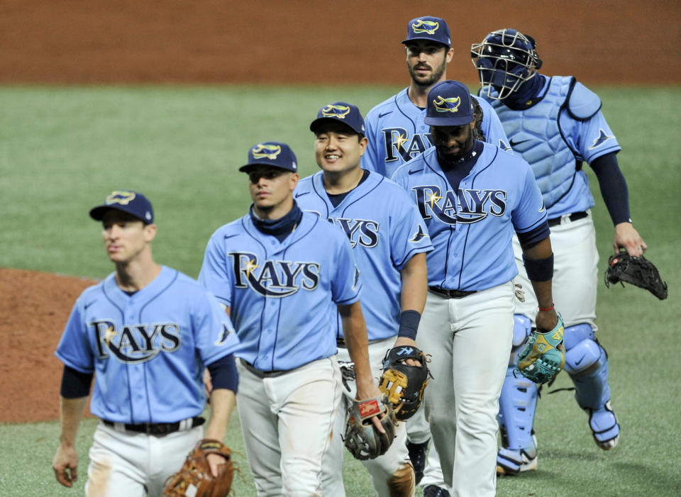 Tampa Bay Rays' Ji-Man Choi, center, smiles as he walks to the dugout with teammates after a win over the Toronto Blue Jays in a baseball game Sunday, Aug. 23, 2020, in St. Petersburg, Fla. (AP Photo/Steve Nesius)