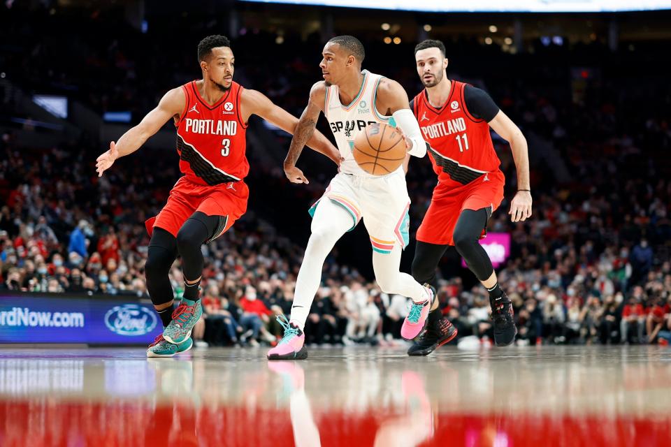 Portland Trail Blazers guard CJ McCollum (3) and forward Larry Nance Jr. (11) defend San Antonio Spurs guard Dejounte Murray (5) during the second half, Dec. 2, 2021, at Moda Center, in Portland.