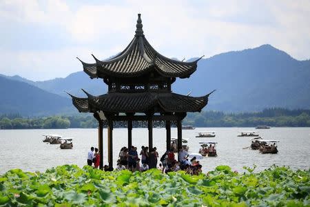 Visitors take shelter from the sun under a pavilion as they visit the West Lake in Hangzhou, Zhejiang province, China, August 3, 2016. REUTERS/Aly Song