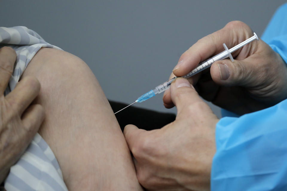 A woman receives Pfizer's COVID-19 vaccine at a vaccination site in Paris, Saturday, March 6, 2021. The government plans to inoculate 10 million citizens by mid-April, 20 million by mid-May and a total of 30 million, or two-thirds of the adults by summer. (AP Photo/Christophe Ena)