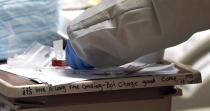 Medical student Engerlina Olivares handles a COVID-19 test from a patient inside the Coronavirus Unit at United Memorial Medical Center, Monday, July 6, 2020, in Houston. Texas is seeing a surge in the number of people testing positive for the coronavirus since it loosened restrictions on gatherings in May. (AP Photo/David J. Phillip)