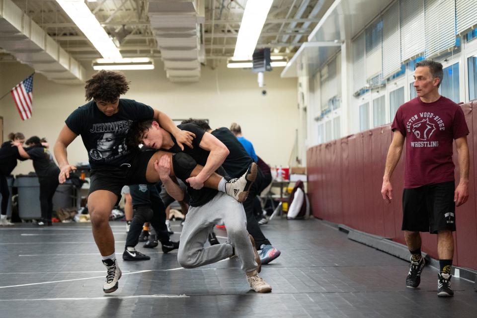 Jan 24, 2024; East Rutherford, NJ, USA; (Right) Becton/Wood-Ridge wrestling head coach Kenneth Herishen looks on as (center) Jordan Stallone and Everett Bell practice.