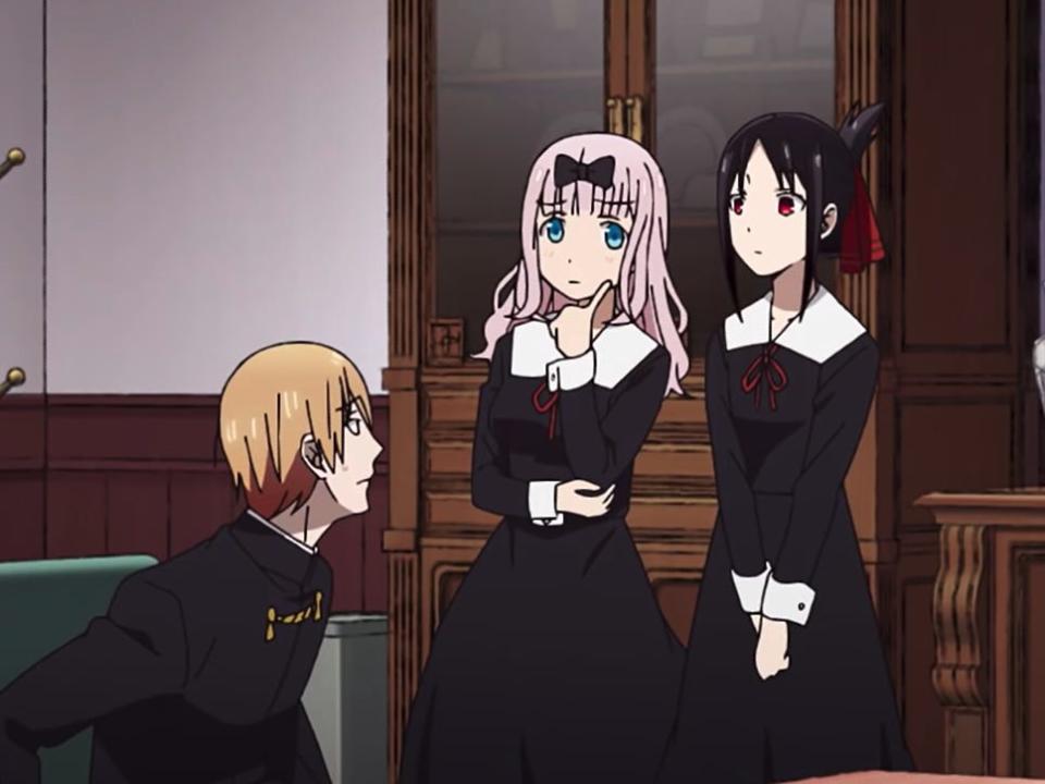 ishigami, miyuki, chika, and kaguya from kaguya sama love is war. ishigami is reading a magazine, miyuki is sitting on a couch, chika has her finger on her face in a thinking pose, and kaguya is standing with her hands clasped in front of her