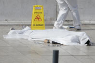 <p>An investigative police officer works by a body under a white sheet outside Marseille ‘s main train station, Oct. 1, 2017 in Marseille, southern France. A man with a knife attacked people at the main train station in the southeastern French city of Marseille on Sunday, killing two women before soldiers fatally shot the assailant, officials said. (AP Photo/Claude Paris) </p>