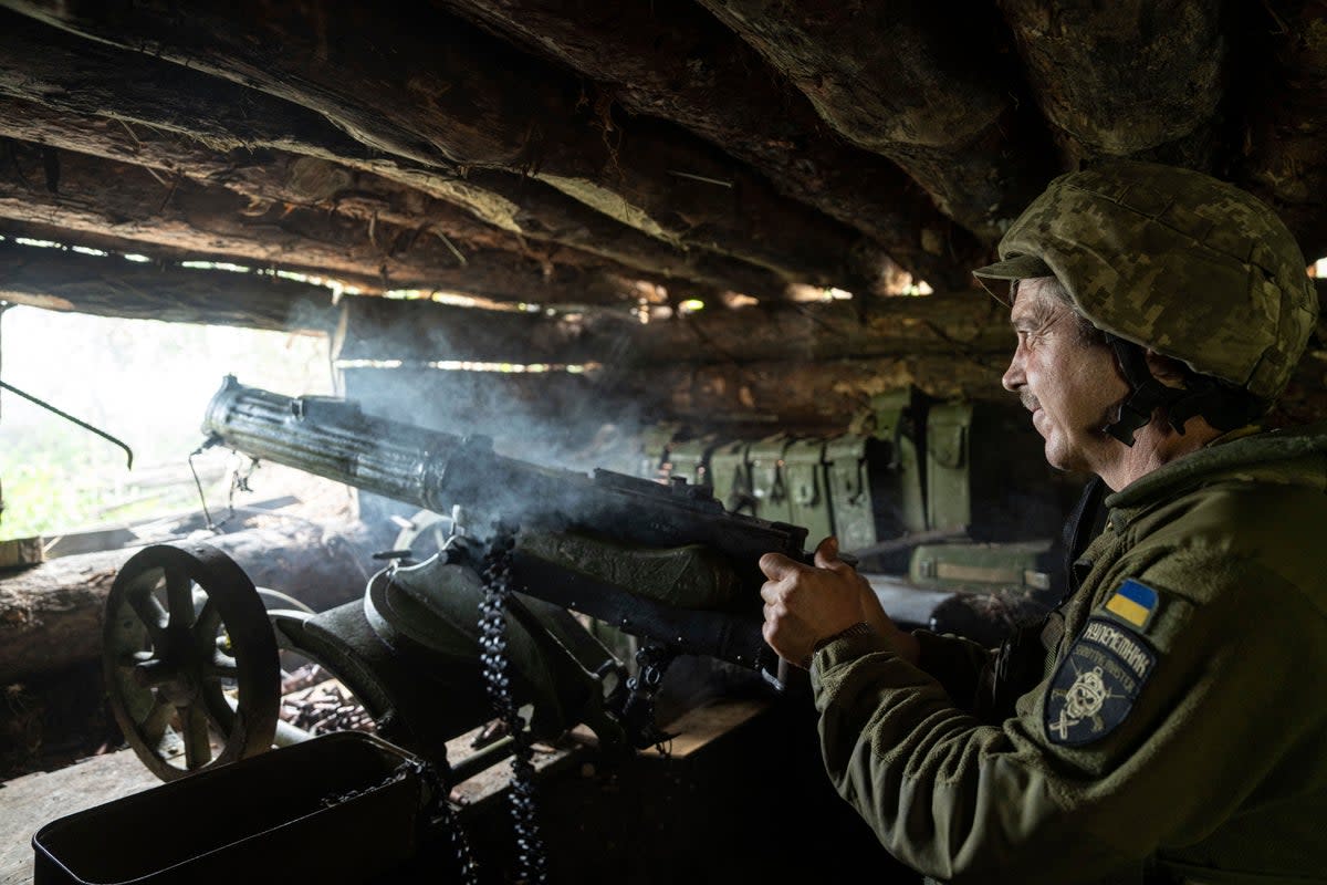 A Ukrainian 28th Brigade serviceman shoots a Maxim gun towards Russian positions at the front line in the eastern Donetsk region (AP)