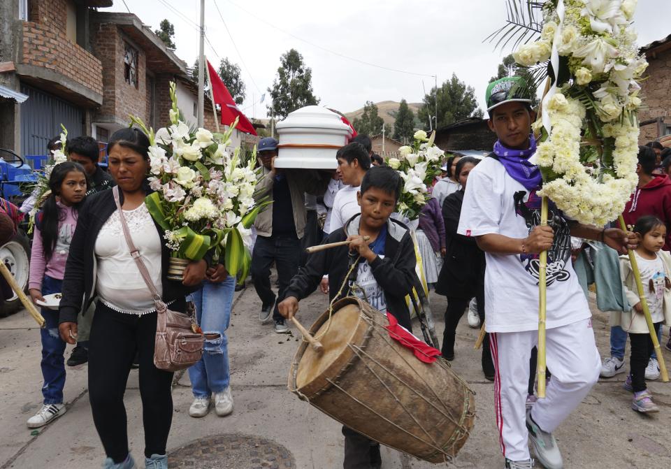 People attend the funeral procession of Clemer Rojas, 23, who was killed during protests against new President Dina Boluarte, in Ayacucho, Peru, Saturday, Dec. 17, 2022. The eight deaths this week that converted Ayacucho into the epicenter of violence in Peru's still unfolding crisis is for many a stark reminder of the region's bloody past and longstanding neglect by authorities in the far-away capital. (AP Photo/Franklin Briceno)
