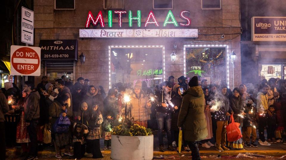 People hold fireworks as they celebrate 'Diwali', the Hindu festival of lights, in Jersey City, New Jersey, on November 12, 2023.